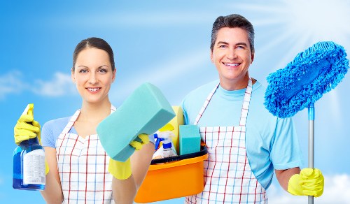 Residential cleaning team organizing and dusting a living area